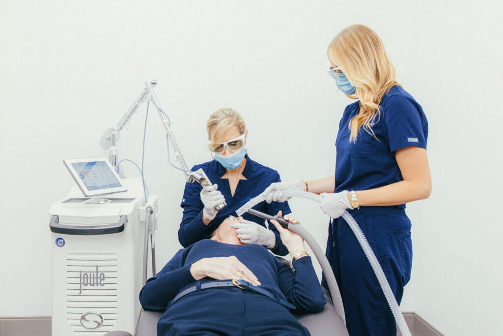 Dermatology Aesthetics of Northern Kentucky's board-certified cosmetic dermatologist near Cincinnati performs a laser treatment on a female patient, assisted by one of our providers.